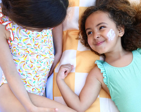 petites filles qui s'appliquent de la creme solaire spf50