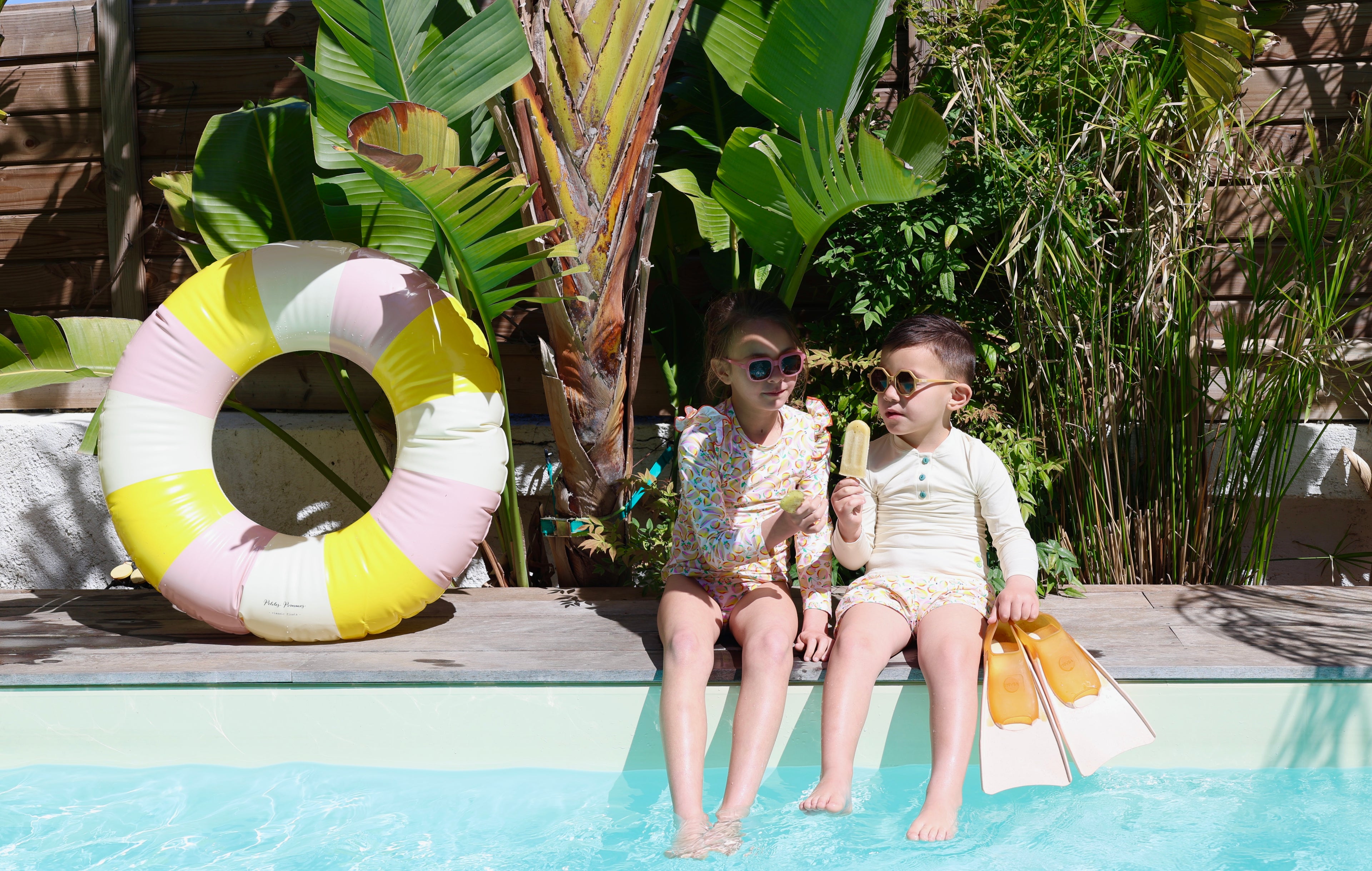 Enfant portant le maillot de bain anti-UV Smoothie Loumio Paris à la piscine, parfait pour se protéger du soleil