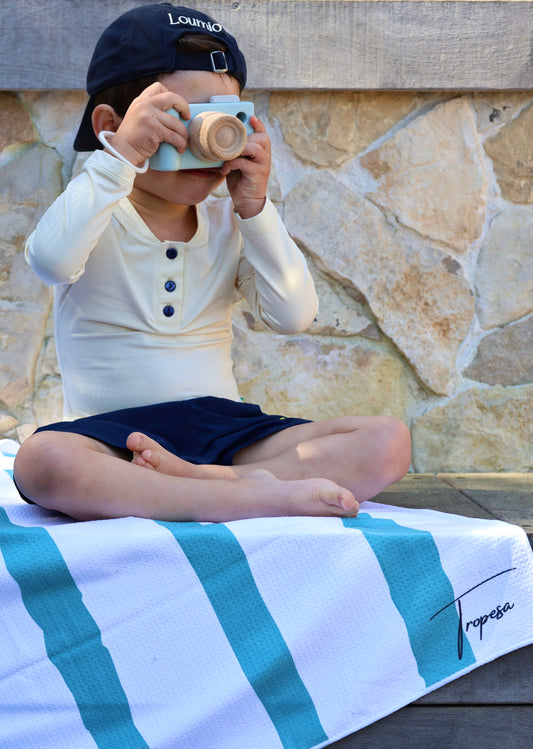 Garçon portant l'ensemble anti-UV Loumio Paris avec le short Orso Deep Blue et le haut Sable, parfait pour une journée ensoleillée à la piscine