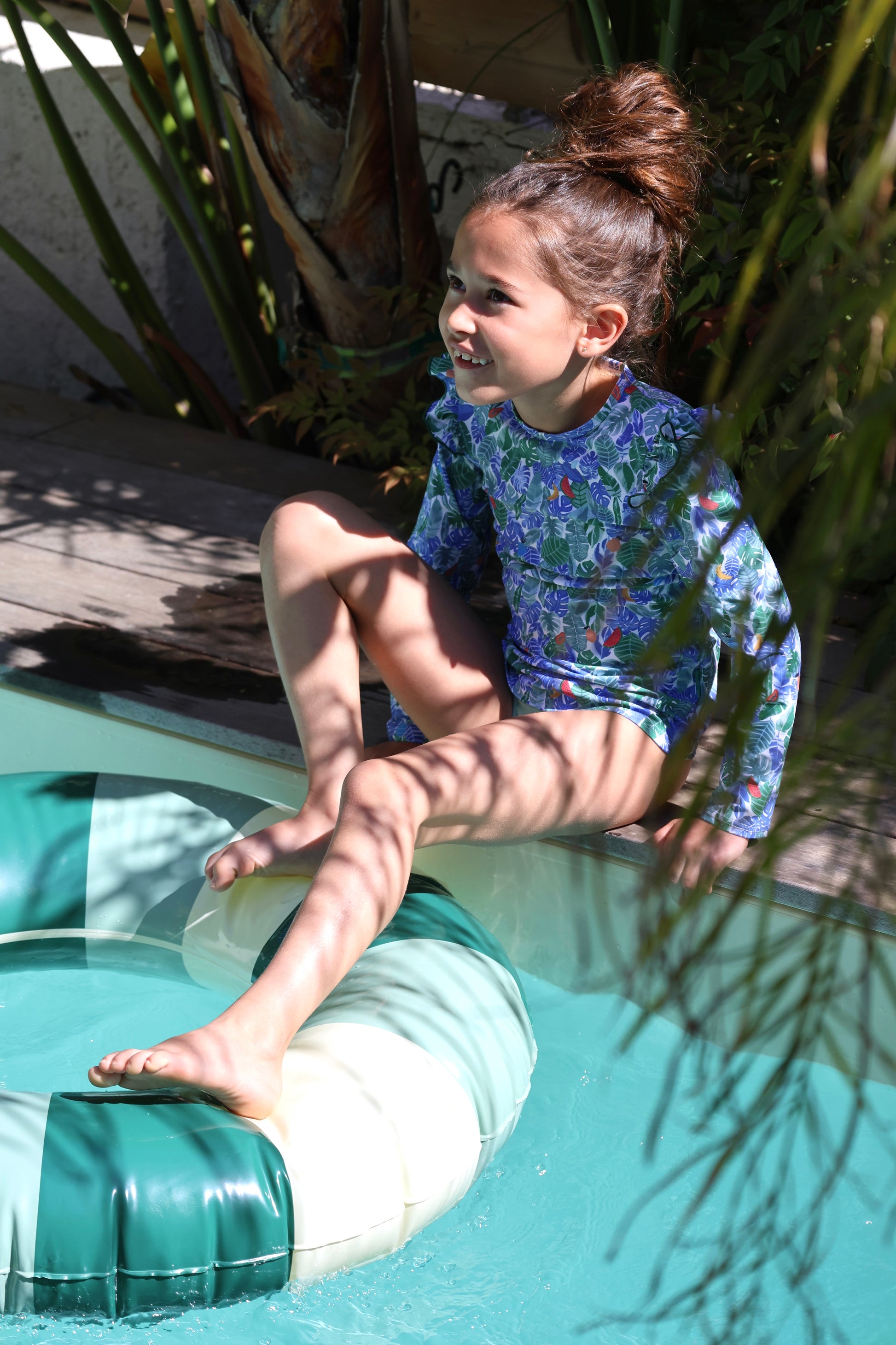 Fille portant le haut anti-UV Eleonore Tropical Jungle Loumio Paris à la piscine, parfait pour se protéger du soleil